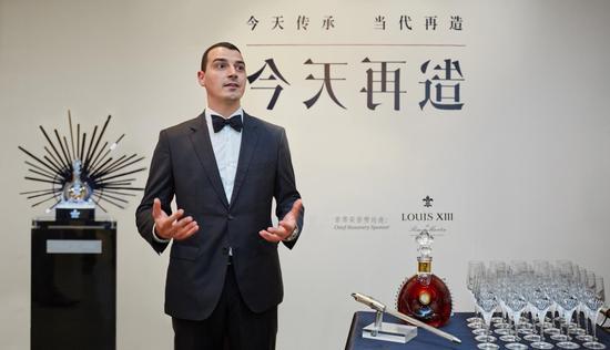 《今天传承·当代再造》首年进程展中来宾在路易十三首席酿酒大师Baptiste Loiseau先生带领下进行了隆重的路易十三品鉴仪式。酒瓶旁的虹吸管由路易十三世代酿酒大师代代相传,是品牌对干邑陈酿工艺和文化传承沿袭的象征。