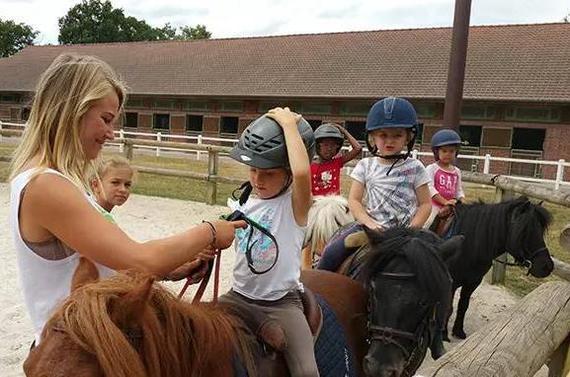 小孩子在马术中心学习骑马