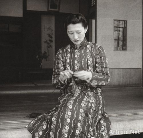 在寓所,张夫人的身后依稀可见挂着的字画
