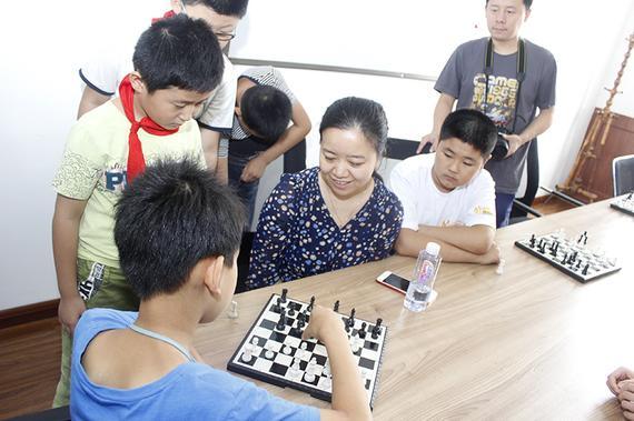 许昱华在给孩子下指导棋。