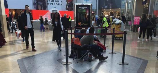 图为英国伯明翰苹果专卖店前等待购买iPhone 6s/6s Plus的用户,由于当地专卖店建在室内,这些用户不会像其他地区的用户一样忍受风吹雨打。