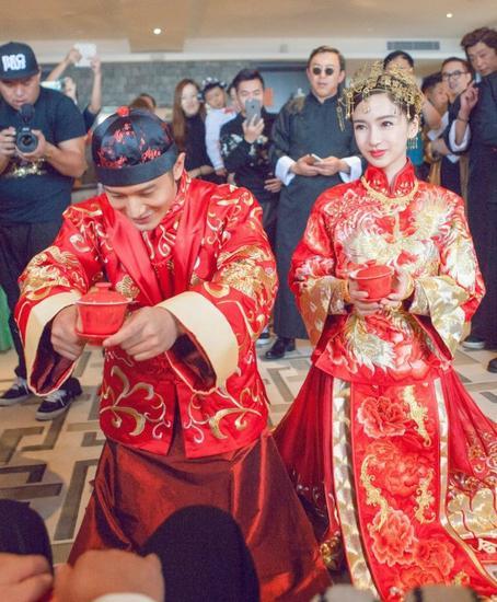 身着中式礼服的教主夫妇跪拜父母