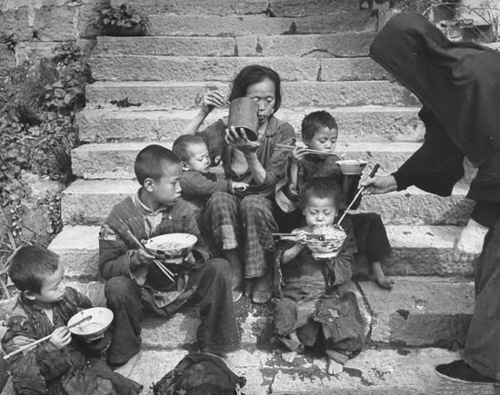 1946年5月,一个饱受战争和饥荒之苦的母亲带着她的五个孩子接受修女的施舍。