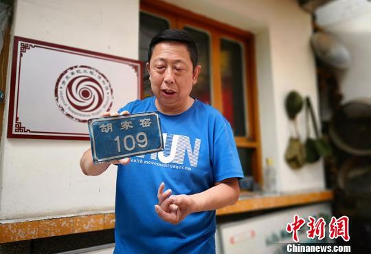 图为彭维国讲述他收藏的门牌号背后“消失的村庄”。 魏建军 摄