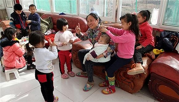 李利娟和她收养的孩子们在一起。图片来源:视觉中国