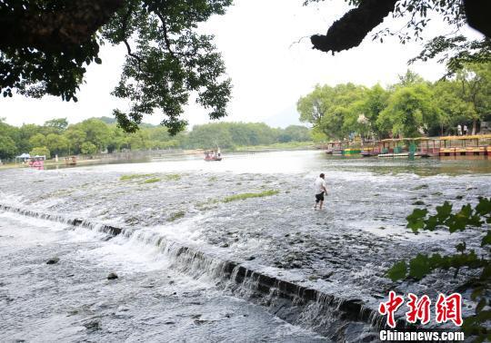 一名工人在清理灵渠水草。 朱柳融 摄
