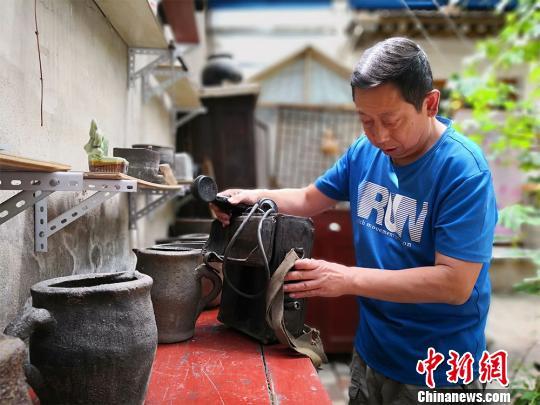 图为彭维国展示他收藏的老式电话。 魏建军 摄