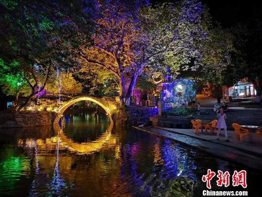 夜幕降临,灯光点缀着灵渠南渠,游客在岸边休闲游玩。 蒙鸣明 摄