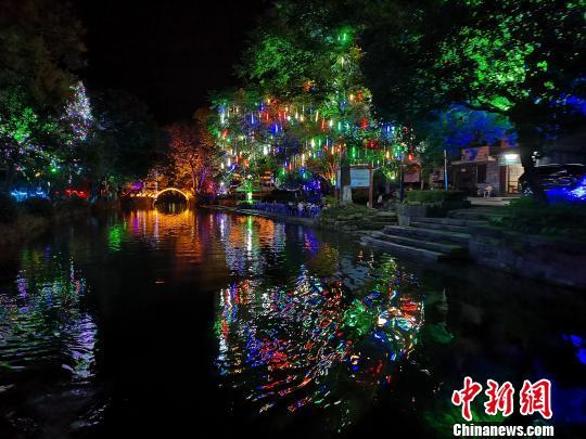 夜幕降临,灯光点缀着灵渠南渠,游客在岸边休闲游玩。 蒙鸣明 摄