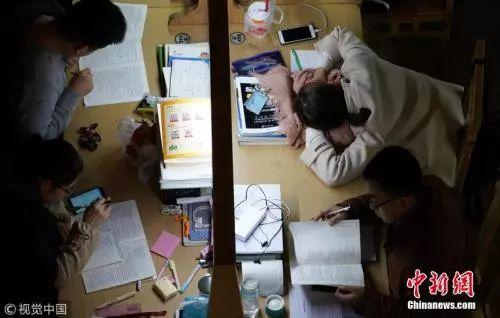 资料图:2017年12月7日,郑州大学新校区,考研进入倒计时。图为夜晚的图书馆里,考研学生占了相当大比