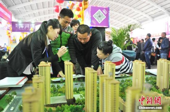 资料图:辽宁省沈阳市,春季房交会现场,销售人员在给市民讲解。孙昊声 摄