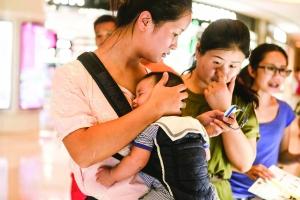 ▲消费者在听销售人员介绍小天才电话手表