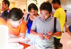 ▲消费者在听销售人员介绍小天才电话手表