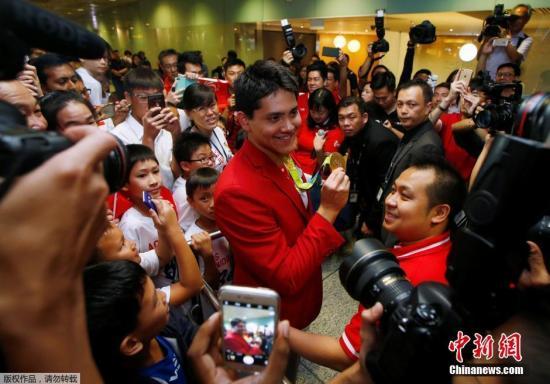 资料图:当地时间8月14日,新加坡游泳运动员约瑟林在奥运会获得男子百米蝶泳金牌后,回到新加坡。在樟宜机场他的粉丝和教练以及众多记者把现场围的水泄不通。