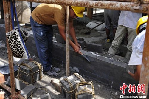 资料图:梁思成林徽因故居部分房屋恢复重建。一名工人正在码齐墙砖。<a href='http://www.chinanews.com/'>中新社</a>发 崔楠 摄