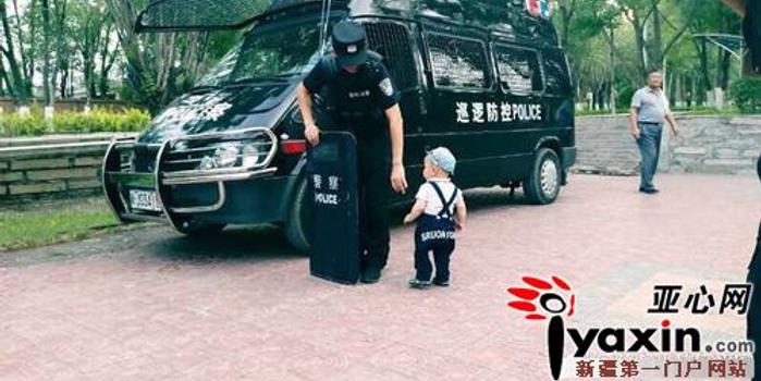 一岁儿子偶遇执勤警察爸爸 求抱抱不成抱着盾