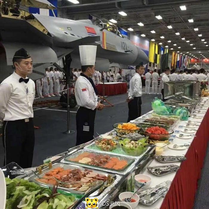 图为甲板招待会现场照片,可见编号121的歼-15舰载机