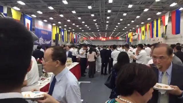 图为视频中香港参观人士在机库现场“大快朵颐”的场景。