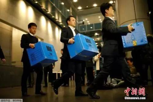 2016年11月8日,韩国检方突击搜查了三星电子在首尔的办公室,检察机关有关负责人将扣押物品箱子拿出来。