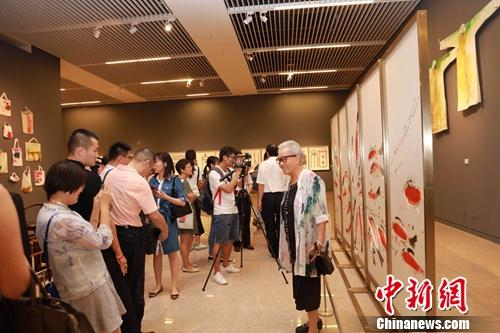 观众们在参观以陈家泠画作为原型创作的《花港观鱼》刺绣艺术品时,啧啧称奇。楼玉峰 摄