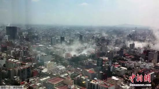 一名市民在墨西哥城地标建筑拉丁美洲塔(Torre Latina)上,用手机拍下了地震后的墨西哥城,建筑倒塌导致城内浓烟四起。
