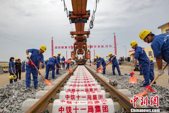 图为,9月21日,建设者在湖北省潜江市境内江汉铁路潜江北站进行最后一排钢轨铺设作业。 徐云华 摄