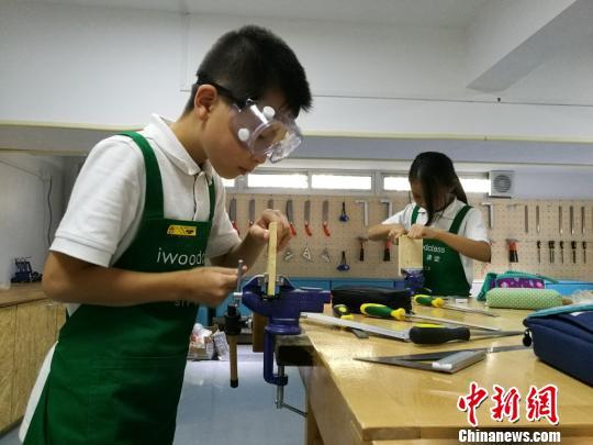 认真地加工木材中。 钟升 摄