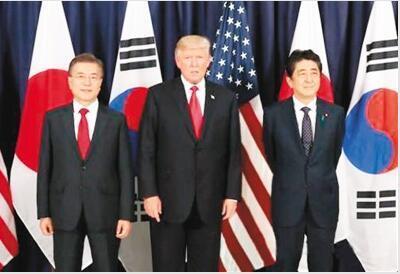 韩国总统文在寅(左)、美国总统特朗普(中)和日本首相安倍晋三在德国共进晚餐前合影留念。图源:韩联社
