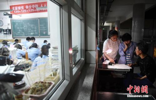 资料图:2018年5月23日晚,河北省邯郸市第一中学,高三学生在教室门口向老师问问题。 中新社发 郝群英 摄 图片来源:CNSPHOTO