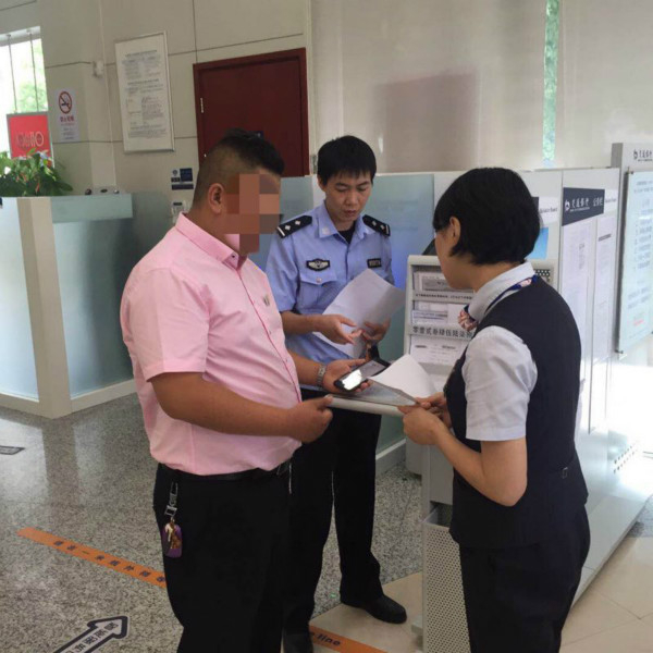图说:民警和店方王先生(粉红衬衫)在银行查询顾客信息。松江警方供图