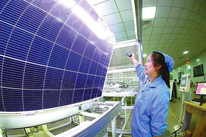 周庄科技产业园内工人们正在组装太阳能电池板组件
