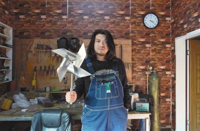 耿帅展示他制作的不锈钢风车。