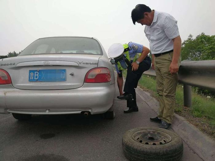 烈日下的守护者：轿车轮胎被扎破 交警热心来帮忙