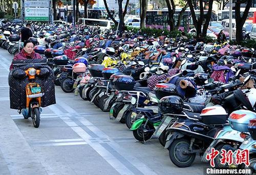 1月16日,福州市民从停车场骑电动车准备出行。 中新社记者 张斌 摄