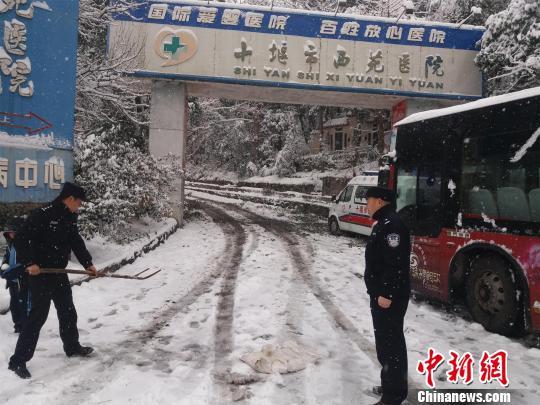 湖北十堰普降大雪,民警除雪保道路畅通 刘英 摄