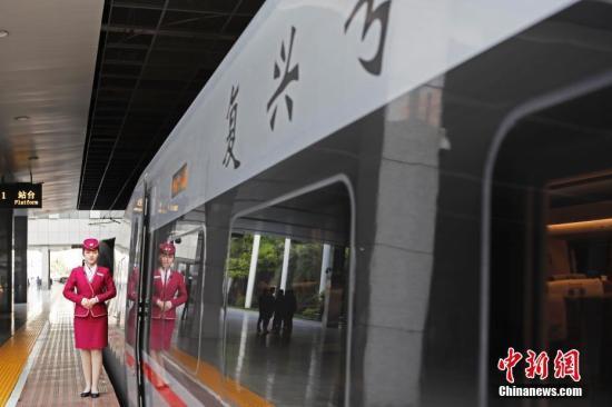 列车员在“复兴号”列车旁迎接旅客的到来。 中新社记者 殷立勤 摄