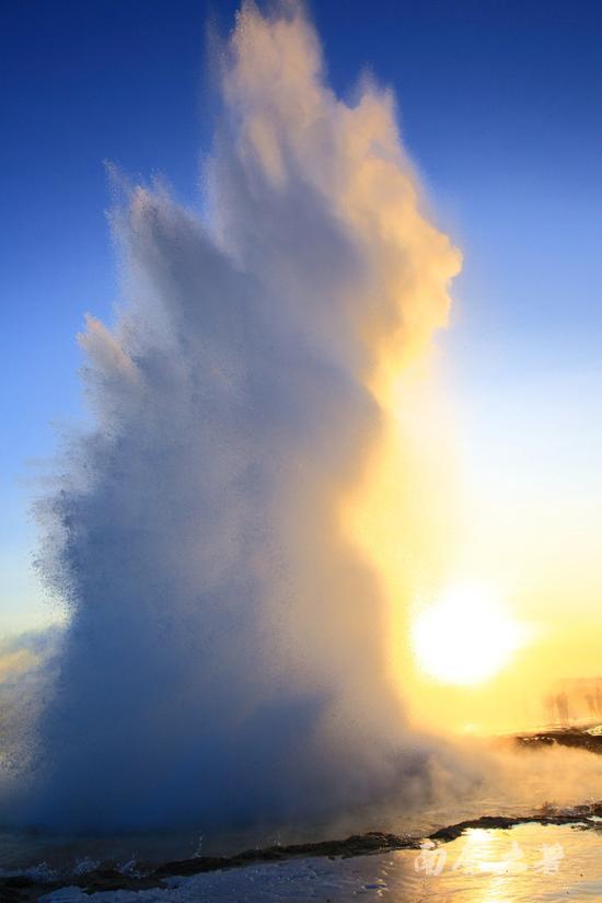 水柱直冲上天空约20多米高,在空中炸开了花,巨大的能量形成瑰丽的水花,阳光下熠熠生辉,化作琼珠碎玉般落下。