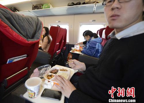 资料图:图为动车组乘客在品尝列车提供的餐食。<a href='http://www.chinanews.com/'>中新社</a>发 侯宇 摄