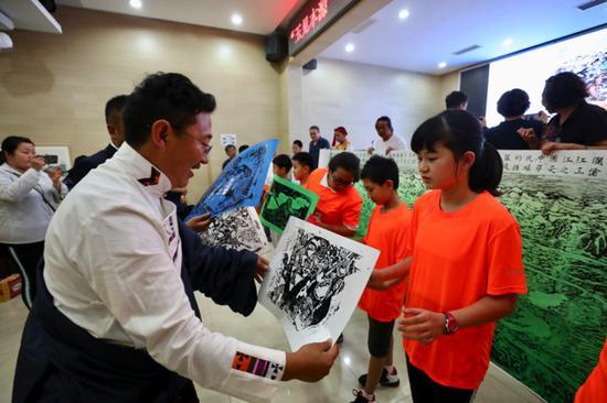 (更尕校长给北京学生赠送玉树孩子的版画作品)