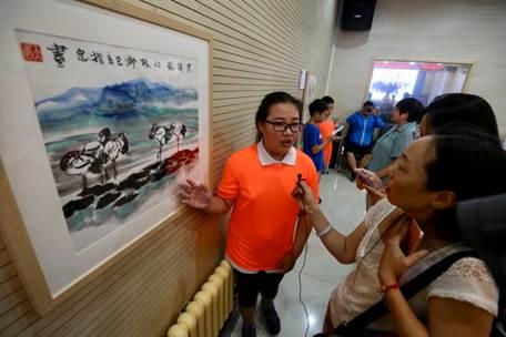 (来自北京西什库小学的小策展人为观众们介绍玉树小朋友作品)
