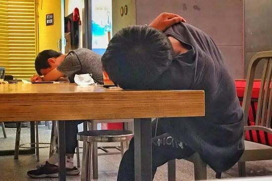 ▲两名男子在肯德基美罗城店休息