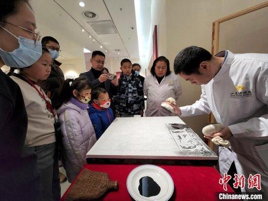 现场展示传拓技艺,吸引观众围观欣赏。赵晓 摄