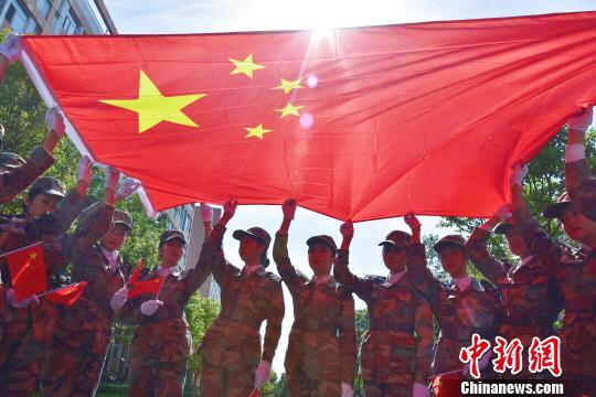 学生与国旗合影。　钟欣 摄