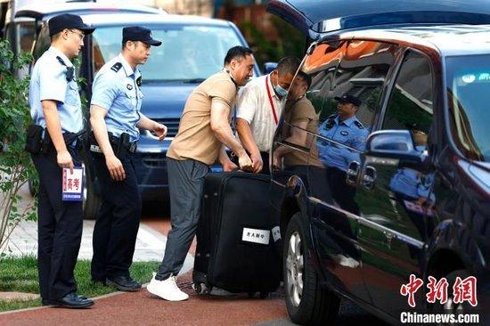 6月7日，在北京市海淀区教育招生和考试中心，工作人员往试卷押运车上搬运试卷。　中新社记者 富田 摄