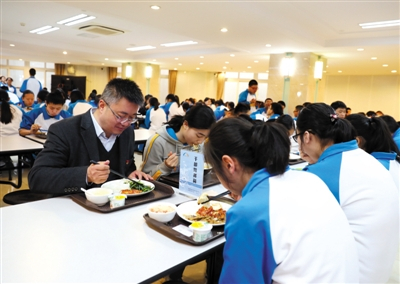 　　3月25日，海淀教师进修学校附属实验学校（北校区）食堂内，校长董红军与同学们一起就餐。新京报记者 王远征 摄