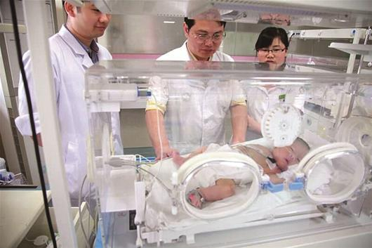 楚天都市报讯 图为：医生查看术后患儿情况