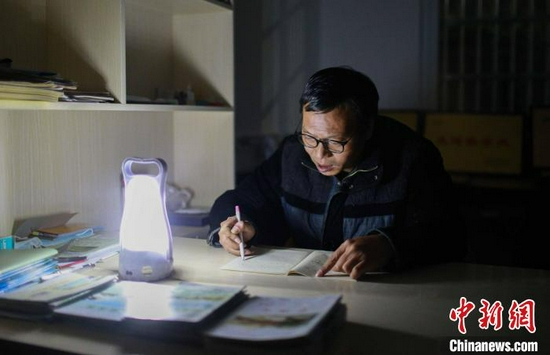 余鹏程在批改作业。　程暑炜 摄