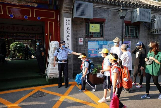 　　9月1日早上，东城公安分局共投入警力200余人分散在区内各个学校守护校园安全，图为民警在黑芝麻胡同小学引导学生进校。东城公安分局供图