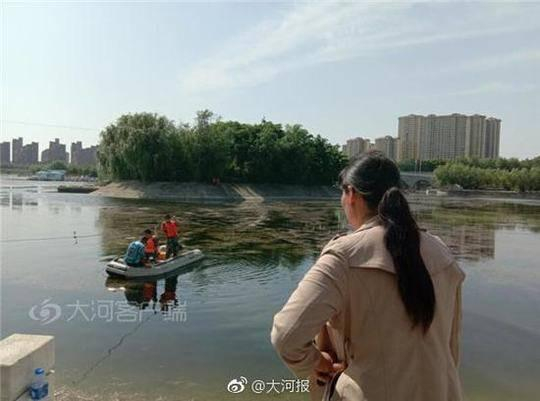 社旗救援队打捞时，落水学生母亲焦急等待的背影。