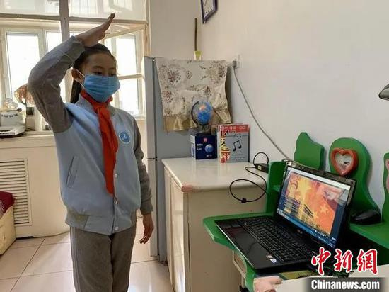 图为少先队员对着屏幕敬队礼。　李捷 摄